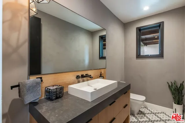 a bathroom with a toilet a sink and mirror