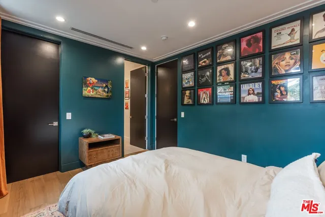 a bedroom with a bed and a wall painting