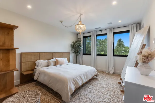 a bedroom with bed and a large window