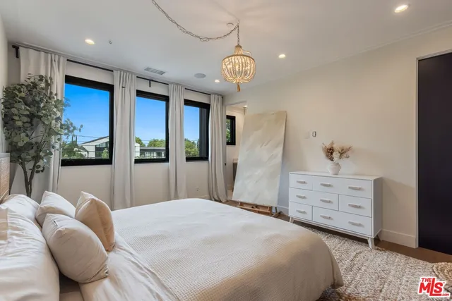 a bedroom with a large bed and chandelier