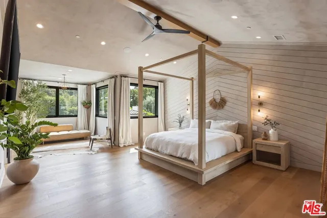 a spacious bedroom with a large bed and a potted plant