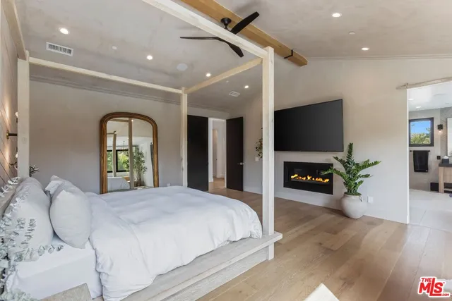a bedroom with a bed and a flat screen tv
