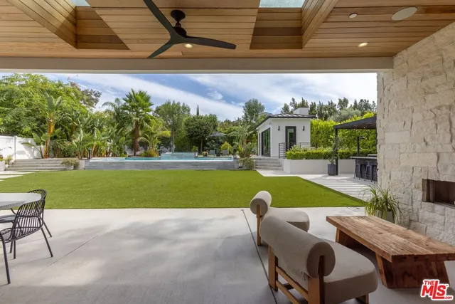 a view of pool with lawn chairs and plants