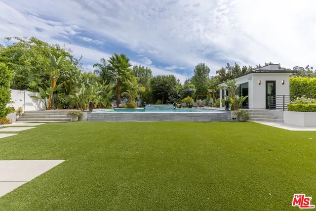 a front view of house with a garden