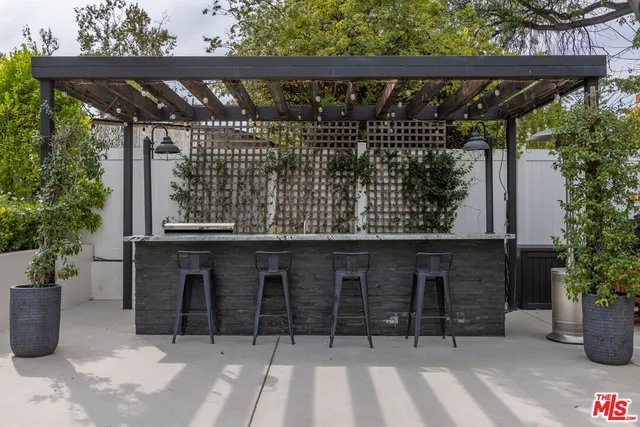 a view of backyard with wheel chair potted plant and large trees