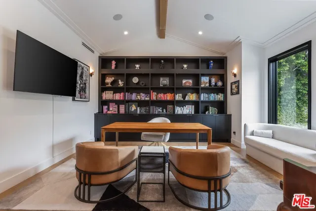 a living room with furniture a flat screen tv and a floor to ceiling window
