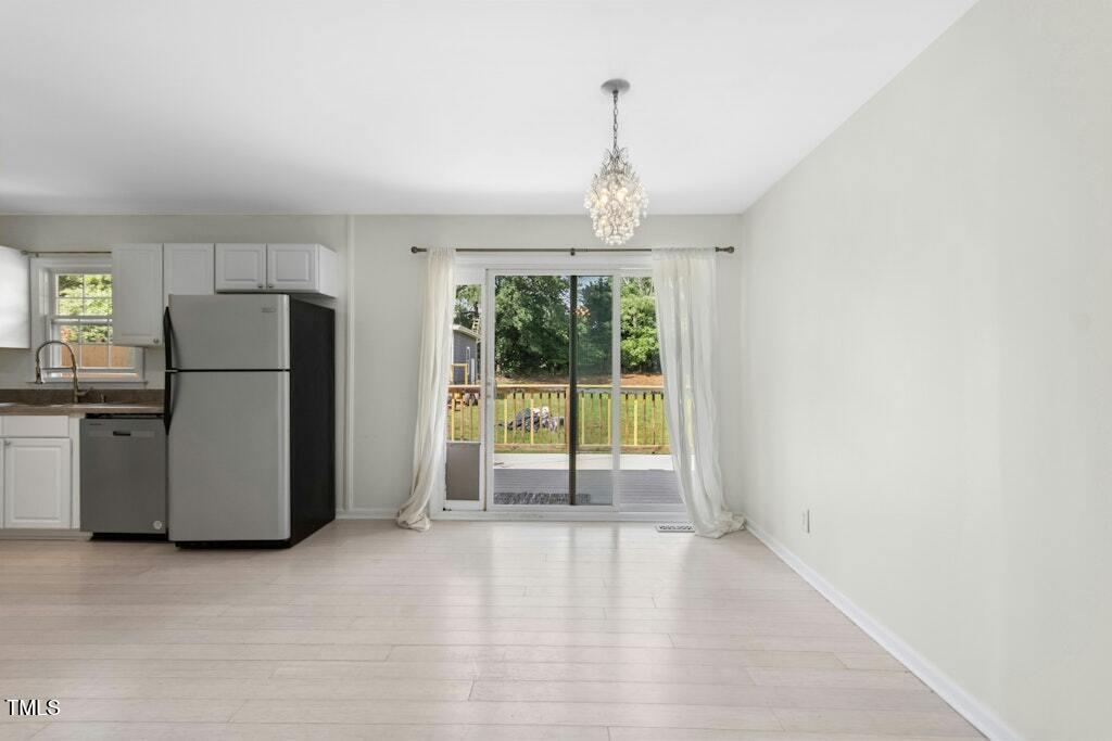 4021 Chaucer Drive Durham, NC 27705 - Photo 12 of 36 a view of a kitchen with a refrigerator cabinets and a wooden floor