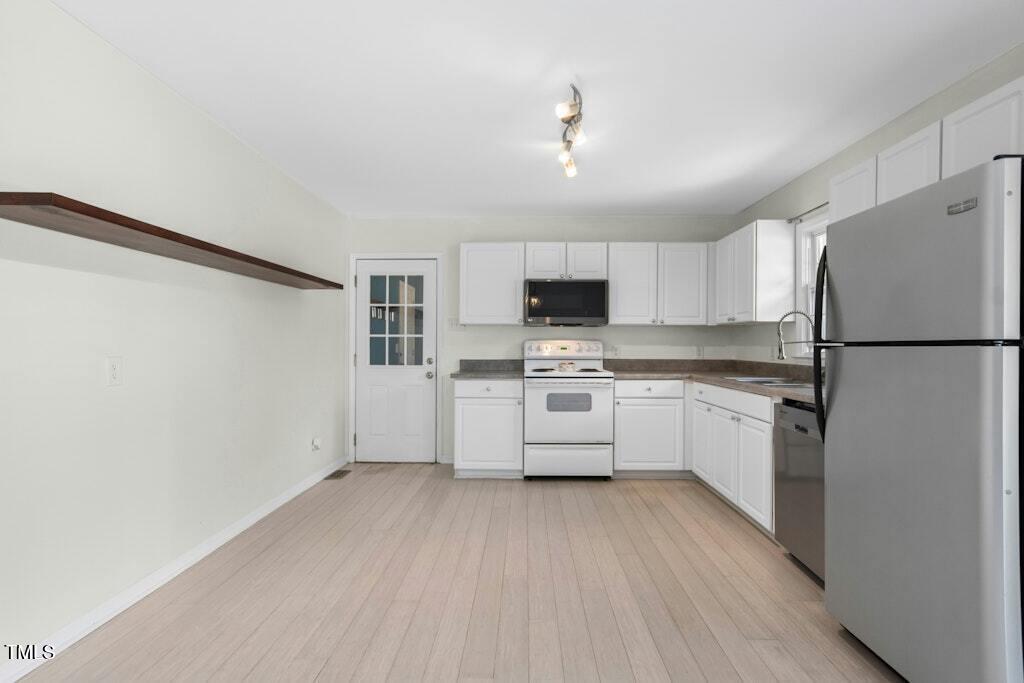 4021 Chaucer Drive Durham, NC 27705 - Photo 13 of 36 a kitchen with white cabinets and stainless steel appliances