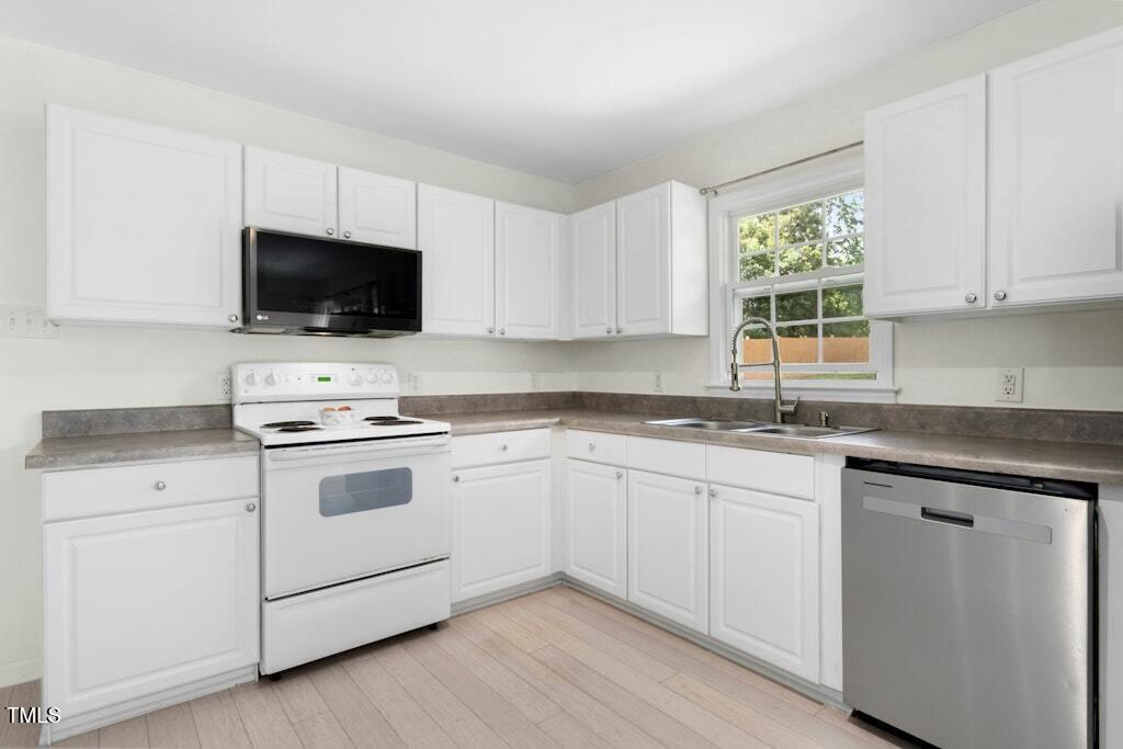 4021 Chaucer Drive Durham, NC 27705 - Photo 14 of 36 a kitchen with cabinets a stove and a microwave