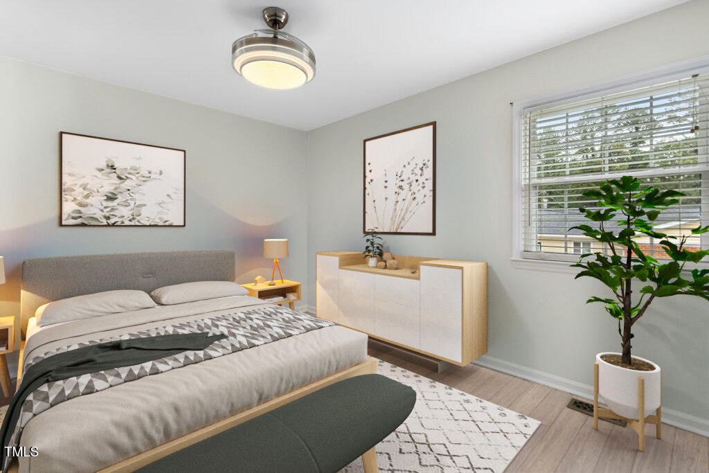 4021 Chaucer Drive Durham, NC 27705 - Photo 17 of 36 a bedroom with a bed and a potted plant