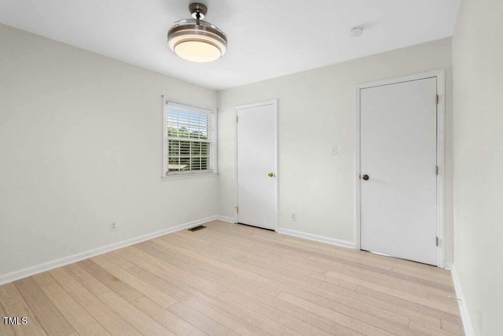 4021 Chaucer Drive Durham, NC 27705 - Photo 18 of 36 a view of an empty room with wooden floor and window