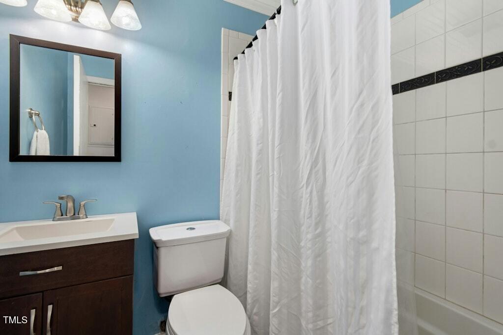 4021 Chaucer Drive Durham, NC 27705 - Photo 28 of 36 a bathroom with a toilet a sink and a mirror