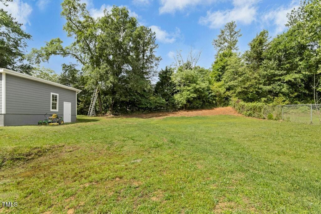 4021 Chaucer Drive Durham, NC 27705 - Photo 32 of 36 a backyard of a house with plants and large tree