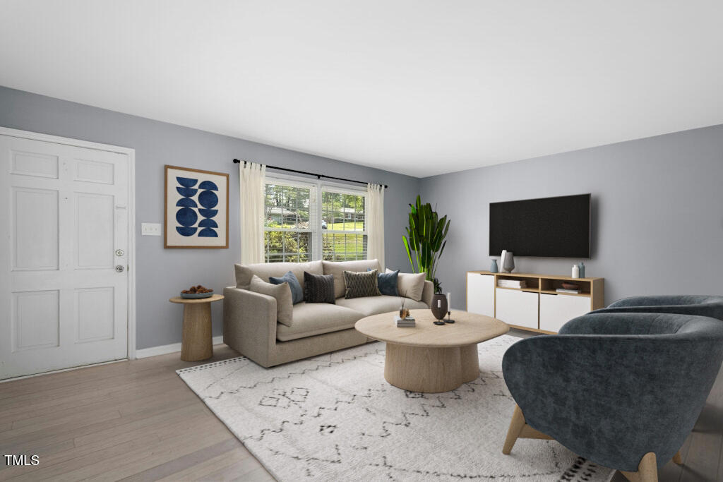 4021 Chaucer Drive Durham, NC 27705 - Photo 5 of 36 a living room with furniture a flat screen tv and a window