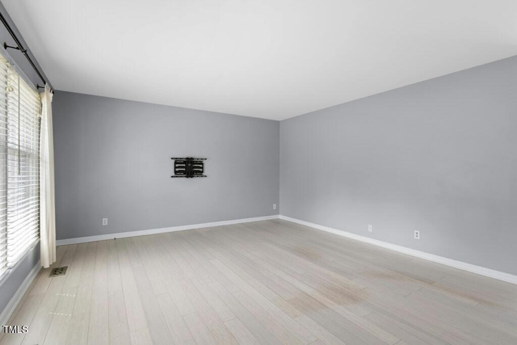 4021 Chaucer Drive Durham, NC 27705 - Photo 6 of 36 an empty room with wooden floor and windows