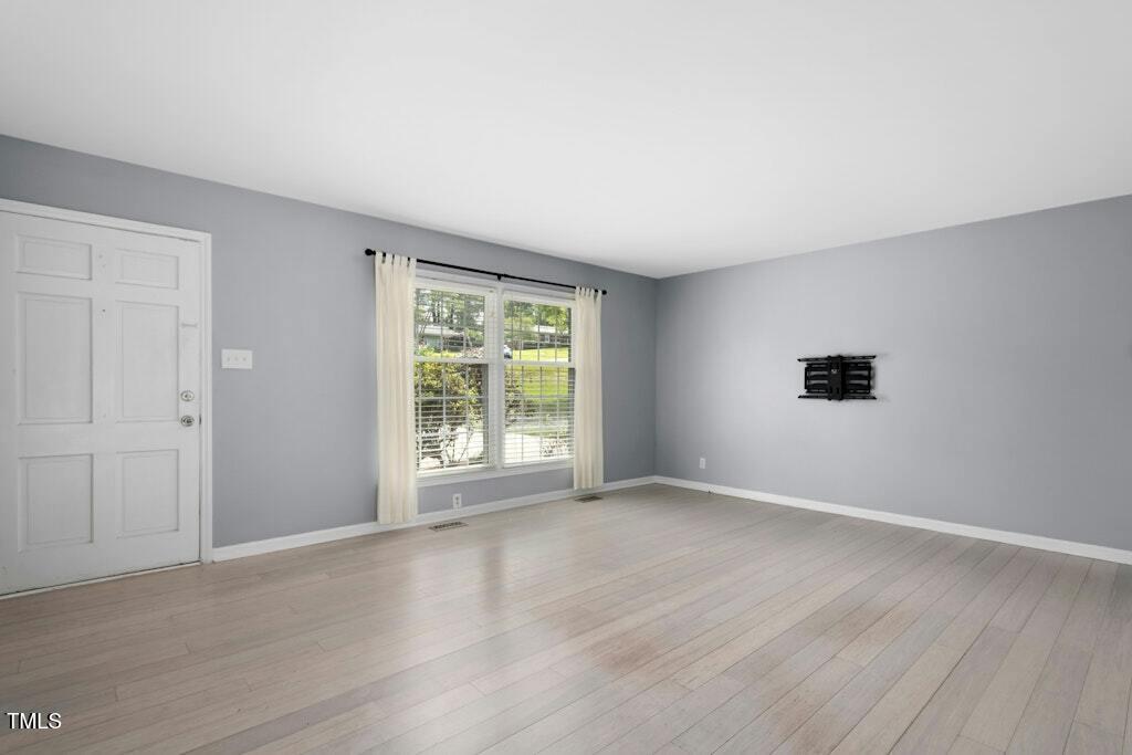 4021 Chaucer Drive Durham, NC 27705 - Photo 7 of 36 an empty room with wooden floor and windows