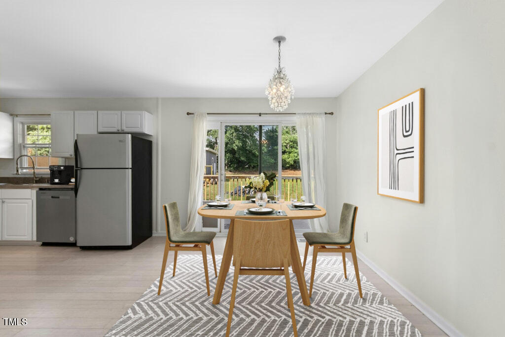 4021 Chaucer Drive Durham, NC 27705 - Photo 9 of 36 a dining room with furniture a chandelier and wooden floor