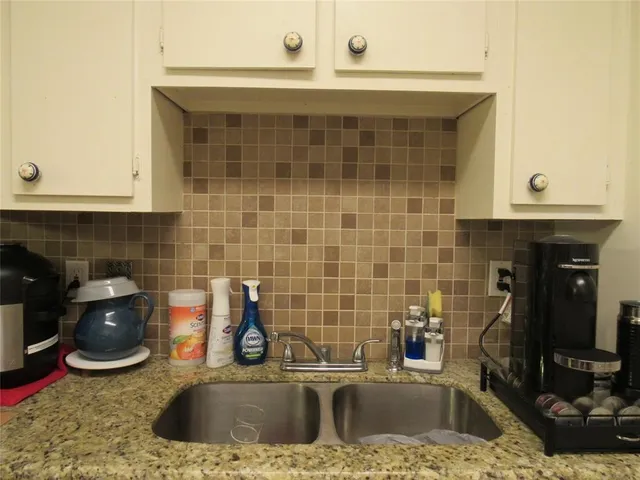a kitchen with a sink appliances and cabinets