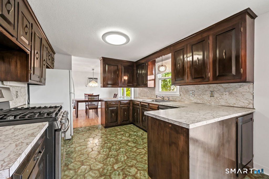 142 Wolcott Hill Road Wethersfield, CT 06109 - Photo 11 of 29 a kitchen with a stove sink and cabinets