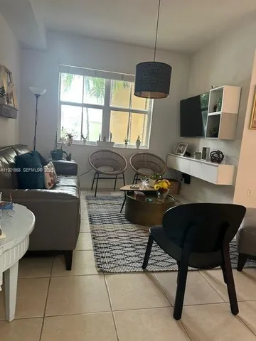 a living room with furniture a flat screen tv and a window