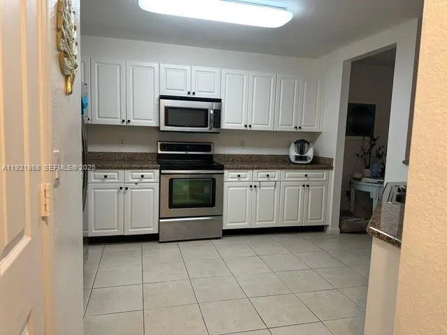a kitchen with stainless steel appliances a stove sink and cabinets