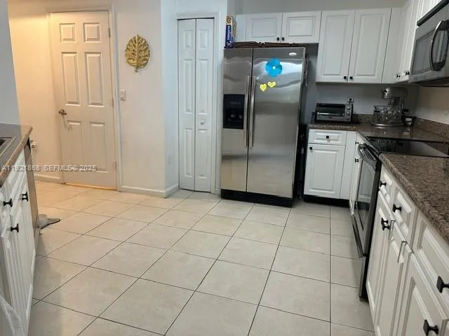 a kitchen with stainless steel appliances a refrigerator sink and cabinets