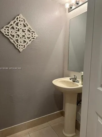 a bathroom with a sink toilet and mirror