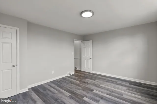 a view of room with wooden floor and white walls