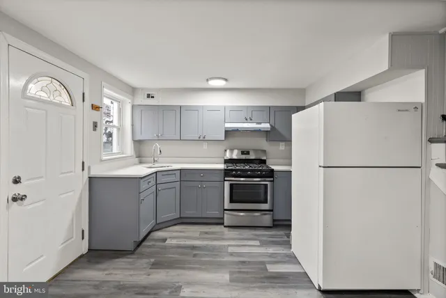 a kitchen with a refrigerator and a stove top oven