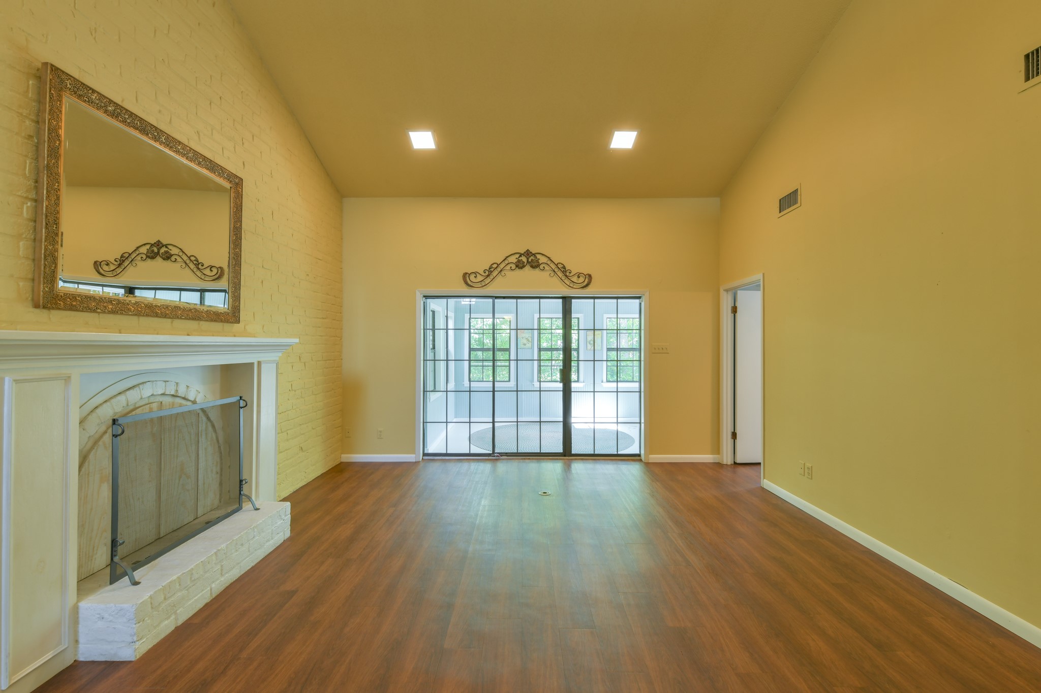 325 East Main Street Brenham, TX 77833 - Photo 3 of 9 a view of a hallway with wooden floor and a fireplace