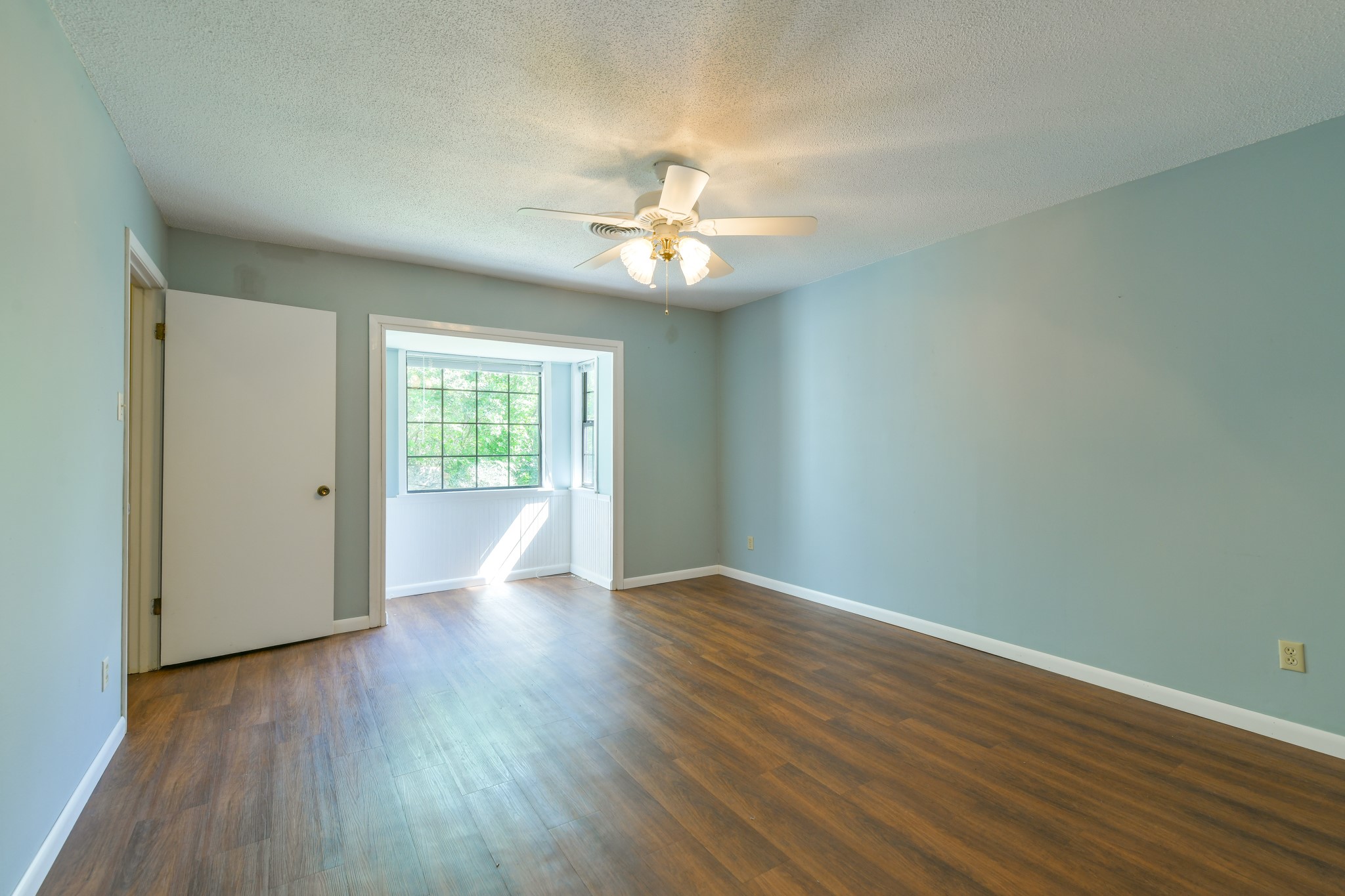 325 East Main Street Brenham, TX 77833 - Photo 7 of 9 wooden floor in an empty room with a window