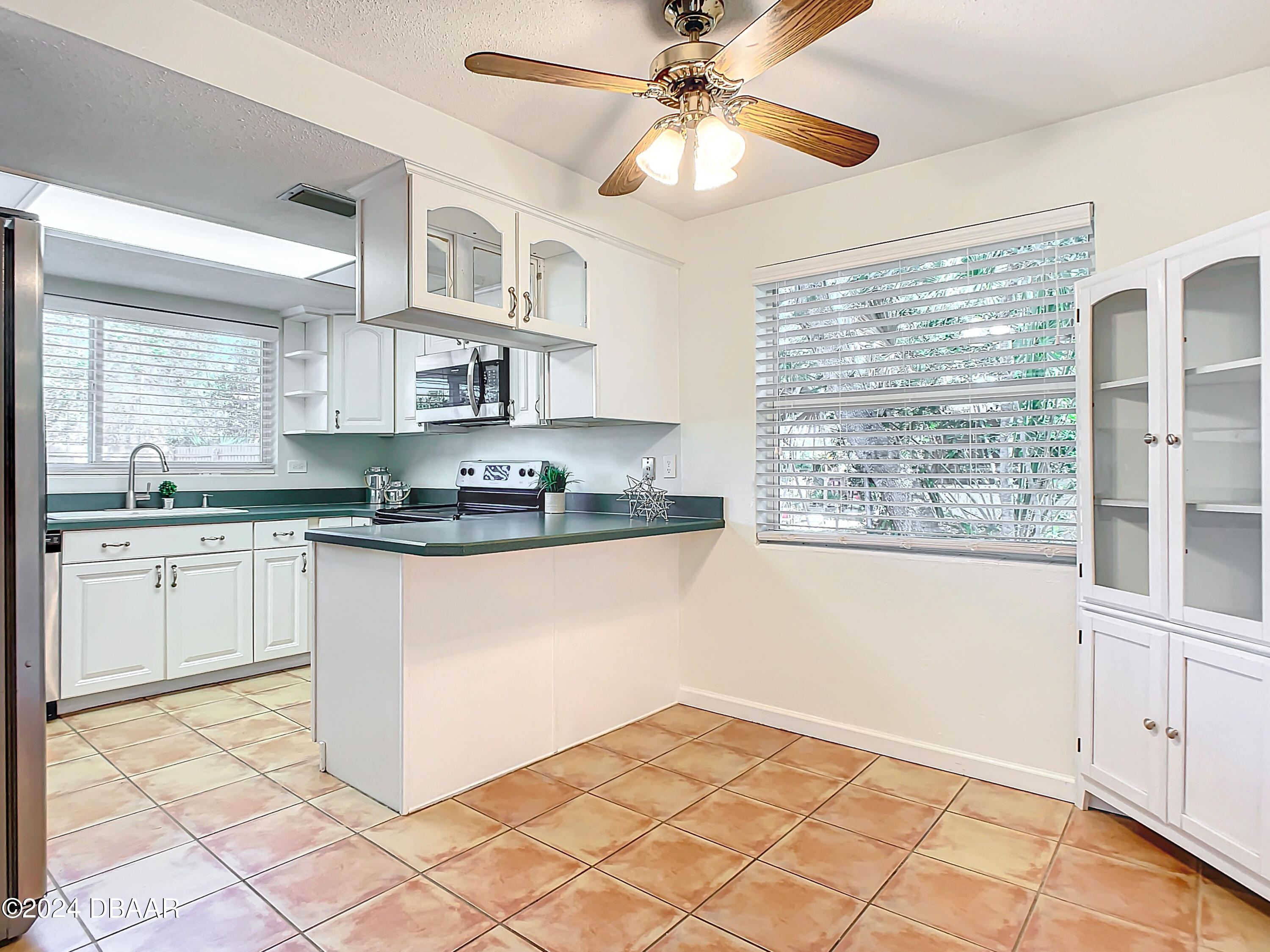 55 Merrywood Circle Ormond Beach, FL 32174 - Photo 14 of 64 a kitchen with stainless steel appliances granite countertop a stove a sink and a microwave