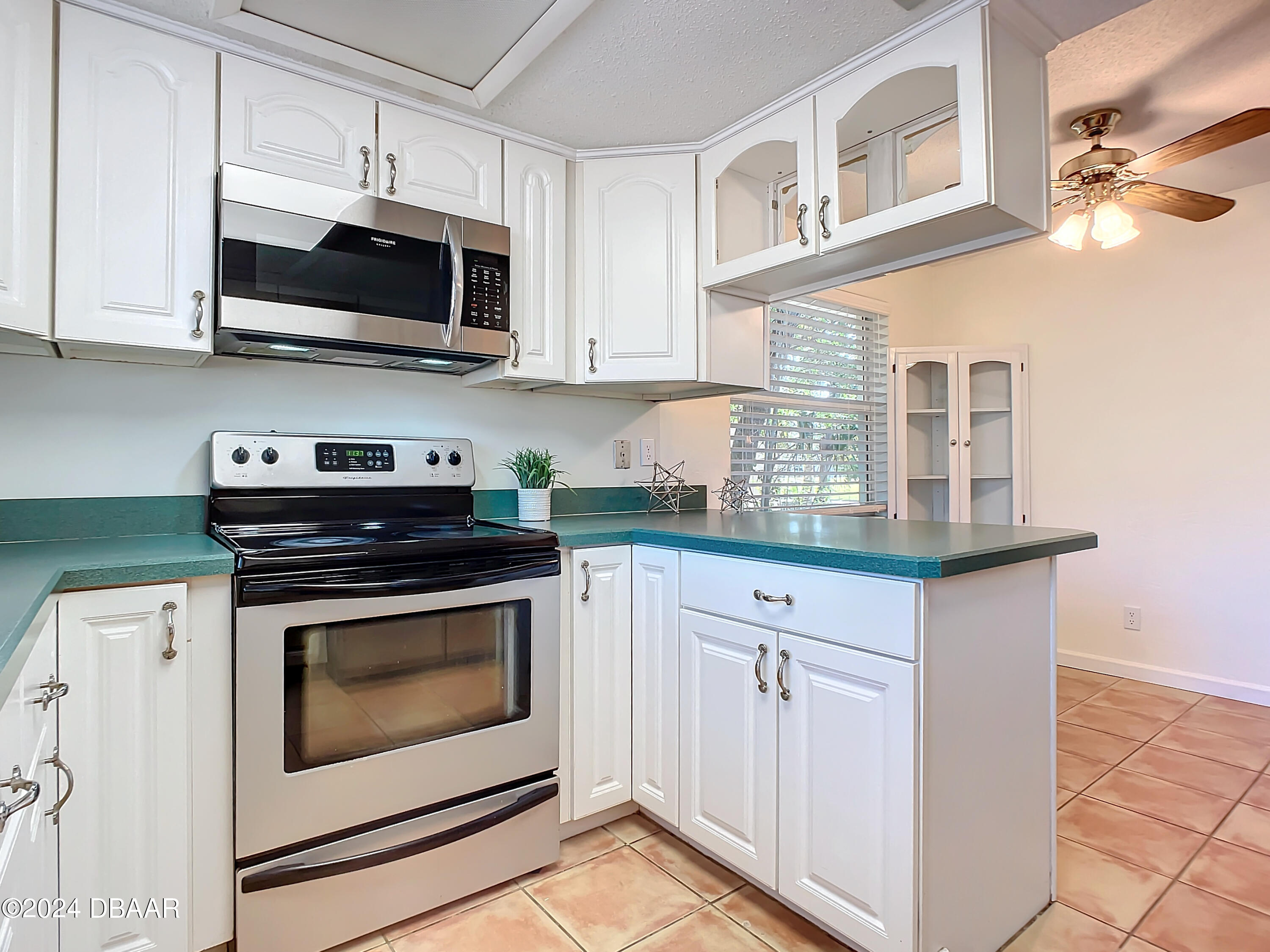 55 Merrywood Circle Ormond Beach, FL 32174 - Photo 18 of 64 a kitchen with stainless steel appliances granite countertop a stove microwave and cabinets