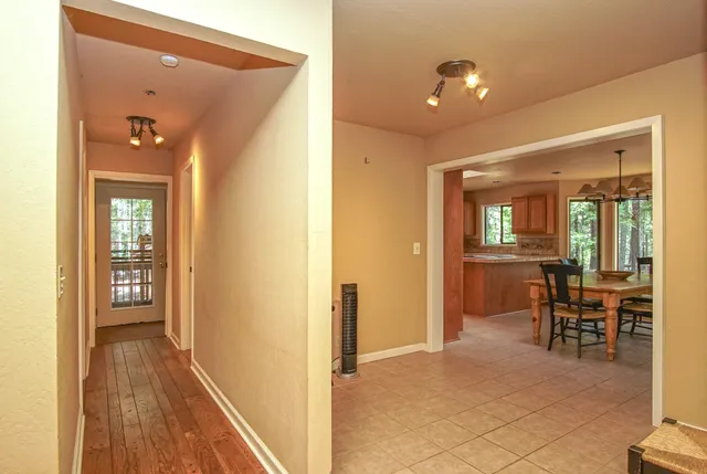 a view of a hallway with wooden floor and dining room