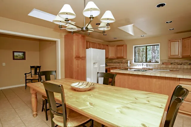 a view of a dining room with furniture and a chandelier fan