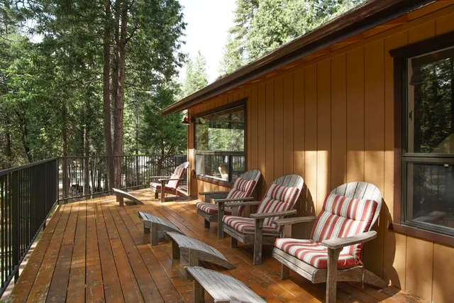 a view of a patio with lawn chairs wooden floor and fence