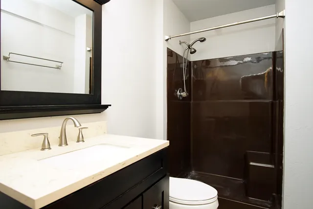 a bathroom with a sink vanity mirror and toilet