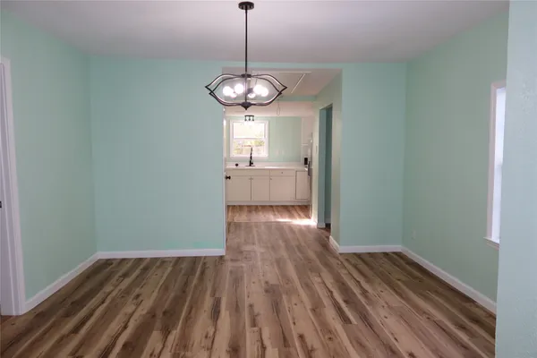 a view of a room with wooden floor and ceiling fan
