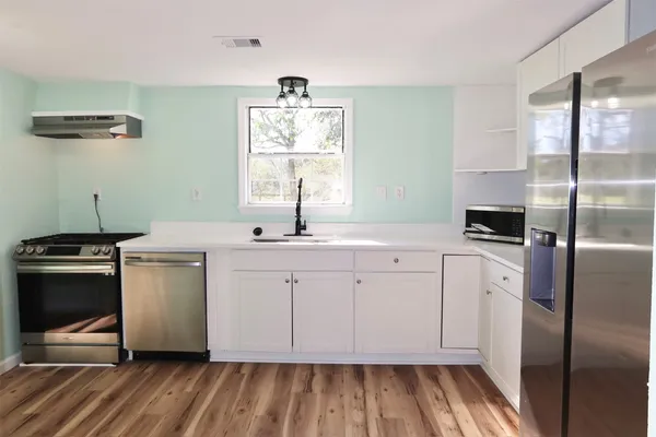 a kitchen with a sink stove and refrigerator