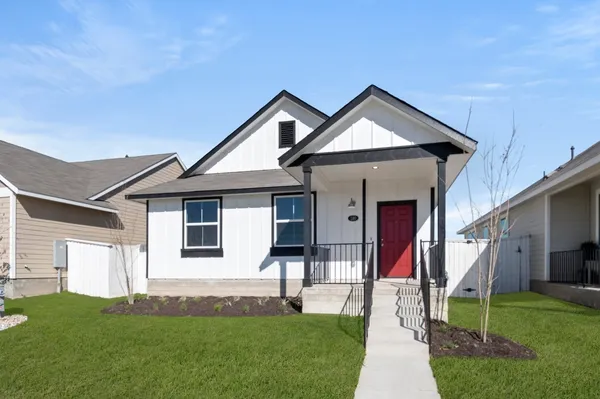 a front view of a house with a yard and trees