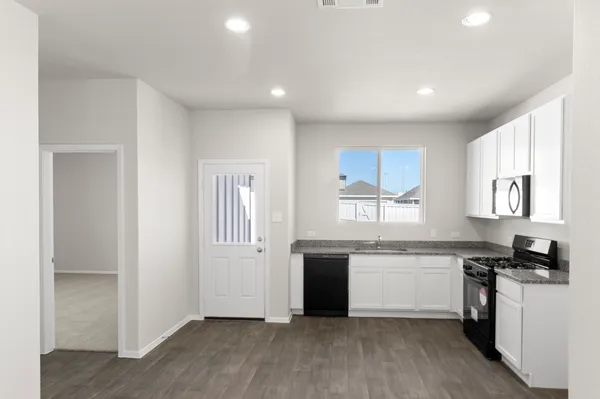 a kitchen with stainless steel appliances a sink a stove a microwave and cabinets