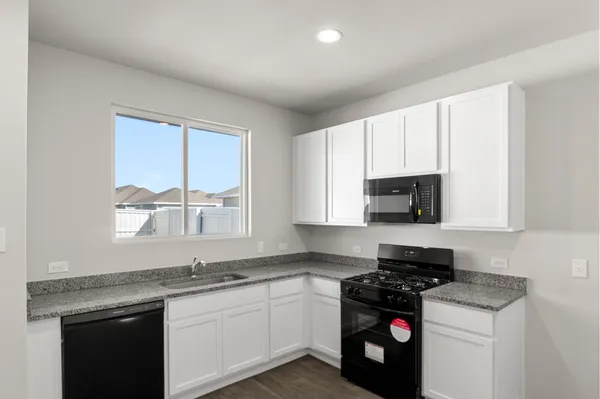 a kitchen with stainless steel appliances a stove a microwave a sink and cabinets