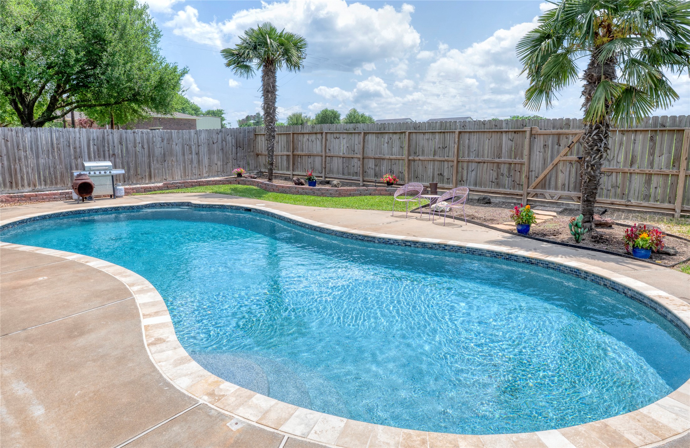 1608 Allison Street Brenham, TX 77833 - Photo 13 of 16 a view of a swimming pool with a seating area and wooden fence