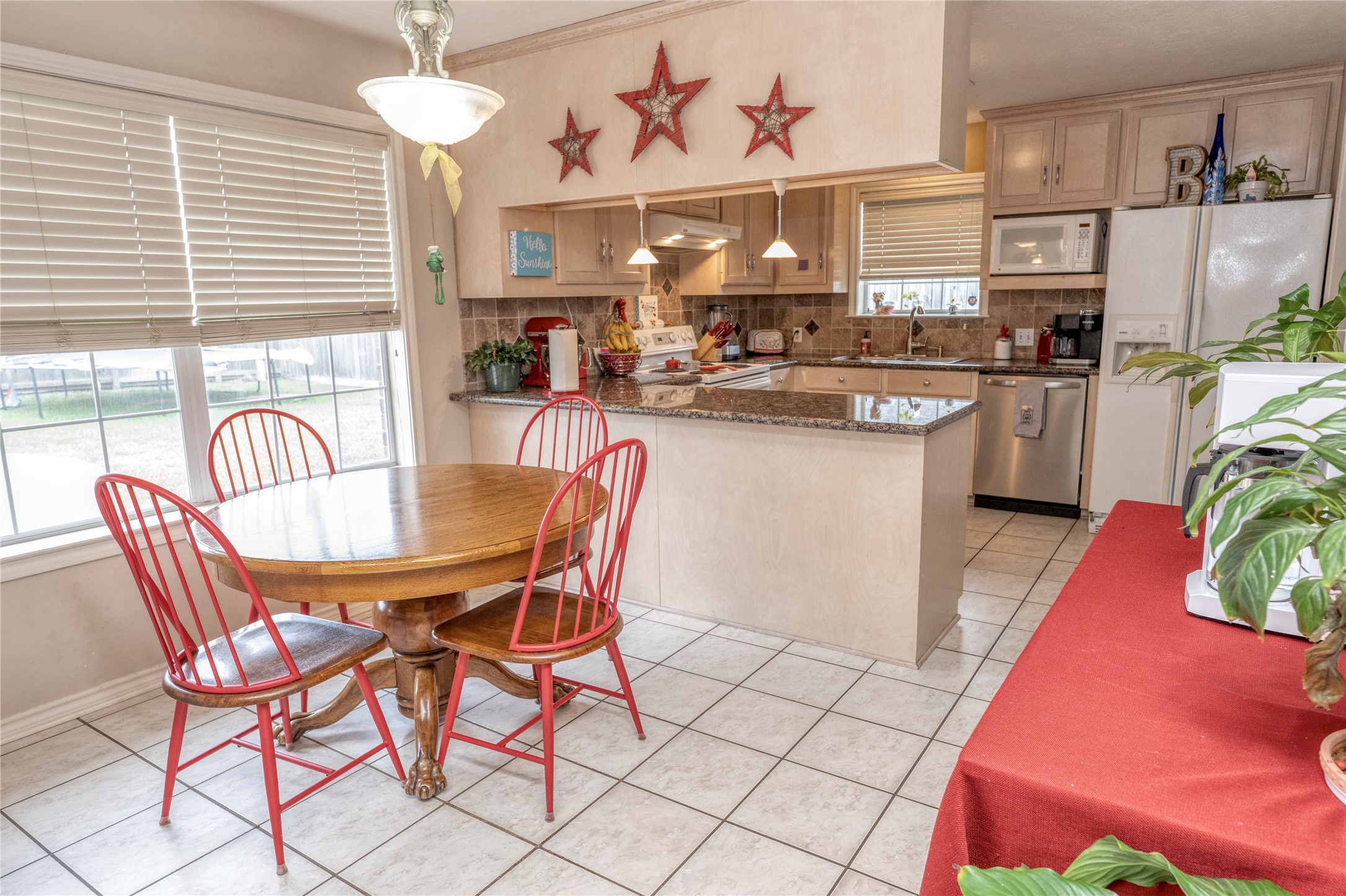 1608 Allison Street Brenham, TX 77833 - Photo 6 of 16 a kitchen with stainless steel appliances kitchen island granite countertop a dining table chairs and granite counter tops