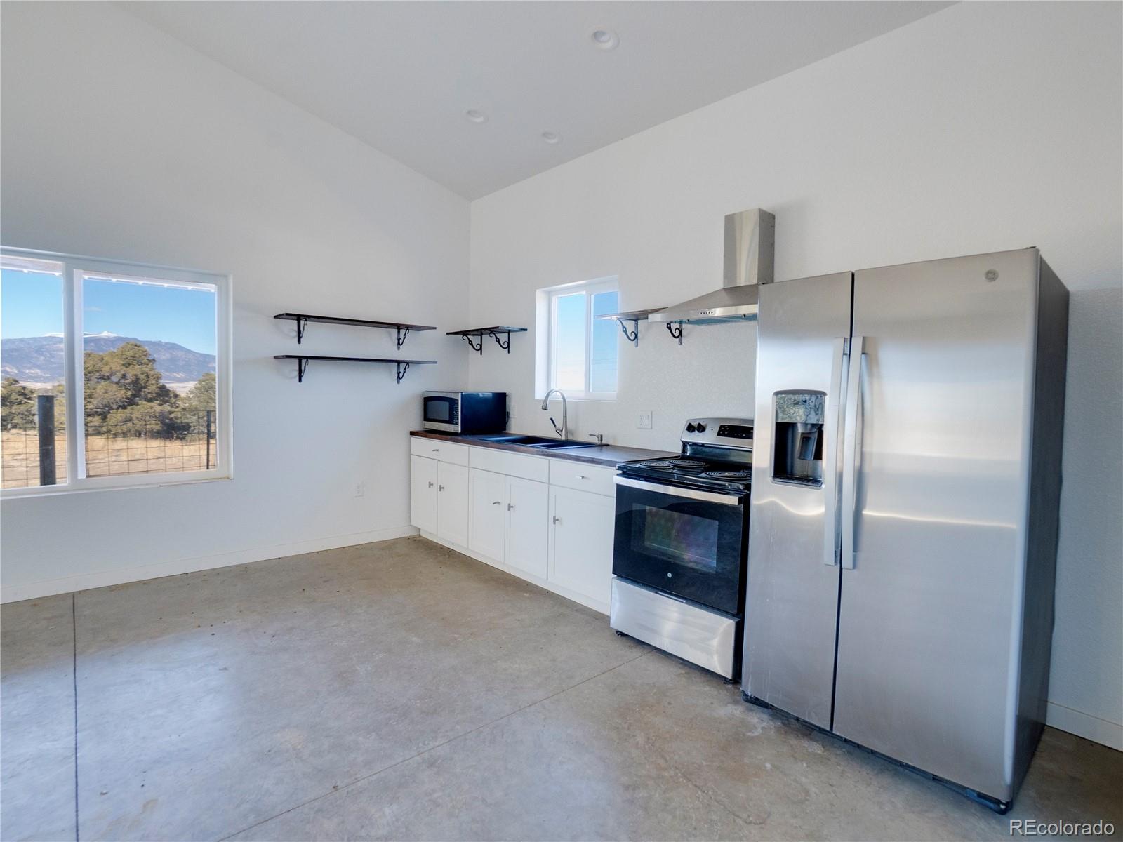 491 Ketchum Road Walsenburg, CO 81089 - Photo 14 of 20 a kitchen with granite countertop a refrigerator and a stove top oven