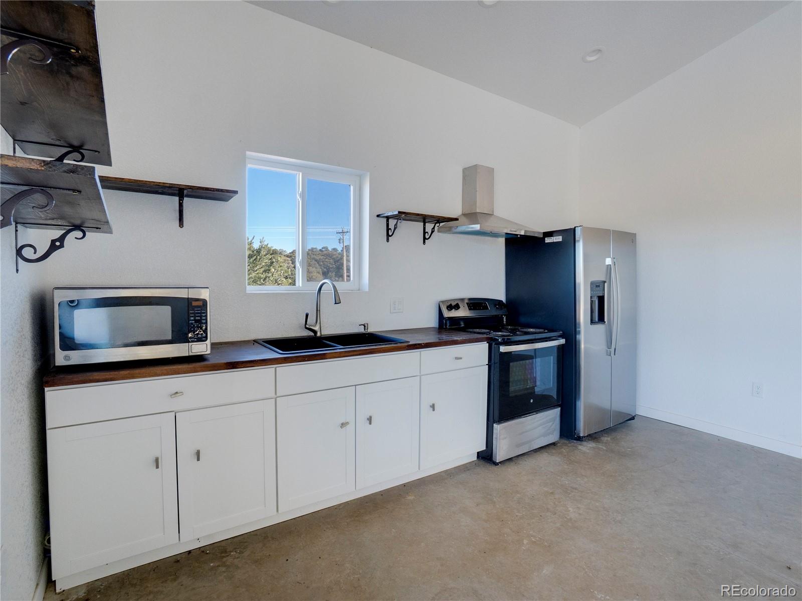 491 Ketchum Road Walsenburg, CO 81089 - Photo 15 of 20 a kitchen with granite countertop white cabinets and stainless steel appliances