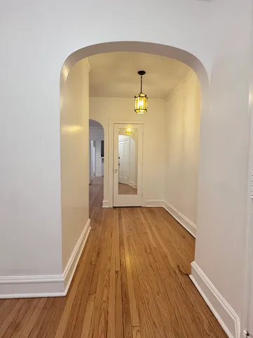 a view of a hallway with wooden floor