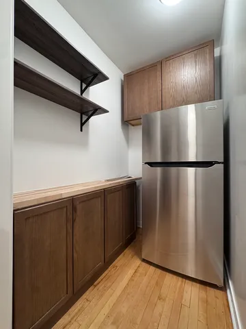 a view of a refrigerator in kitchen and wooden floor