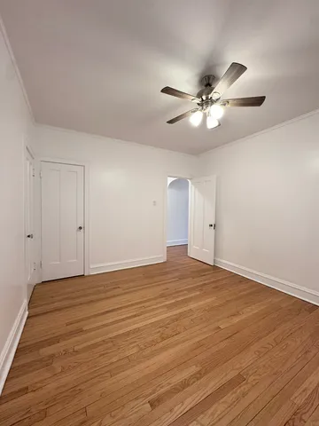 a view of an empty room and chandelier fan