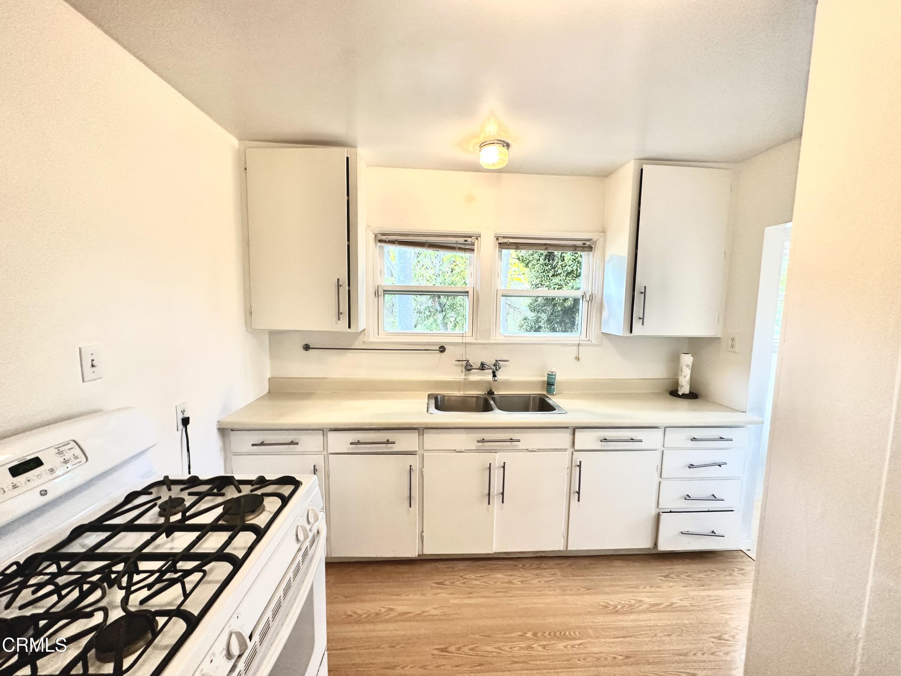 9817 Commerce Avenue Tujunga, CA 91042 - Photo 6 of 7 a kitchen with stainless steel appliances a sink a stove and a window